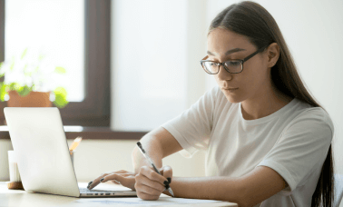 A focused student using academic translation services to enhance the value of research papers and academic documents.